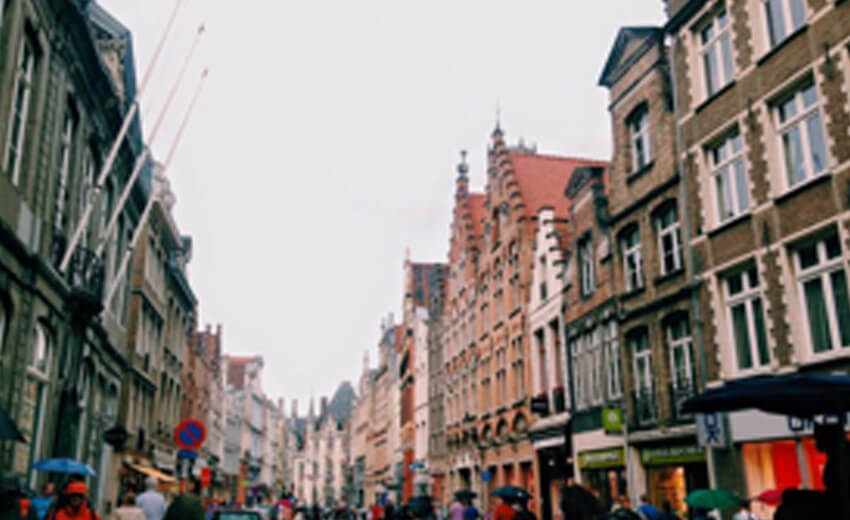 A shopping street in Bruges lined with stepped gable facades