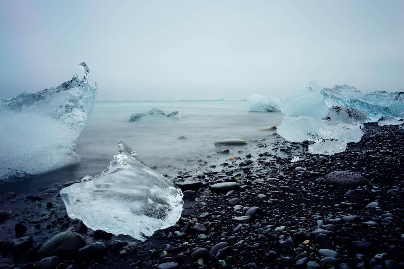 Chunks of glacier ice stranded on a black pebble beach in Iceland