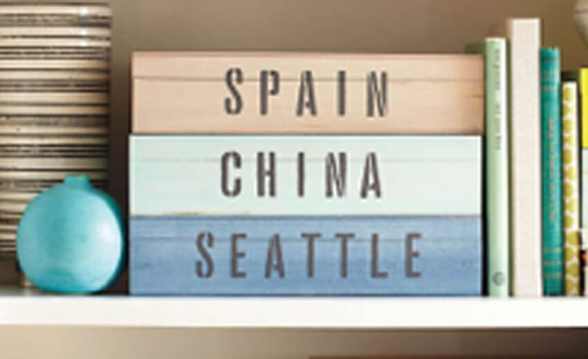 A shelf of books spine-labelled Spain, China and Seattle beside a turquoise globe