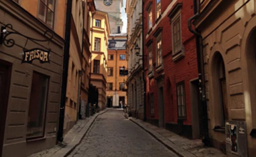 A narrow lane in Gamla Stan, Stockholm, ochre and red buildings on both sides