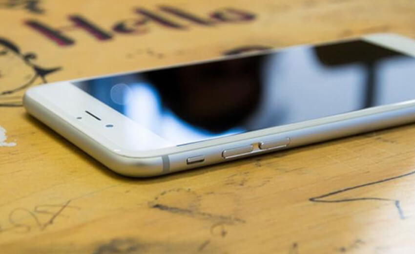 A smartphone lying face up on a wooden table
